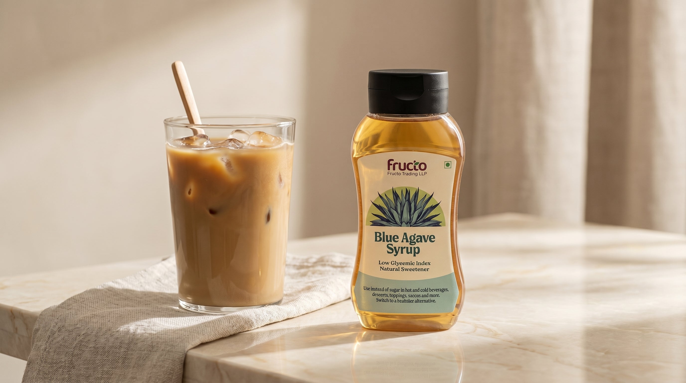 Fructo Blue Agave Syrup hero — bottle with iced coffee on marble